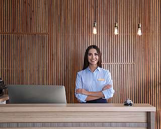 Freundliche Rezeptionistin in einem modernen Empfangsbereich.