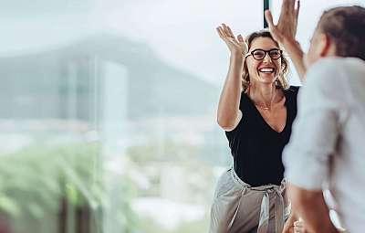 A woman laughs and interacts cheerfully with colleagues.